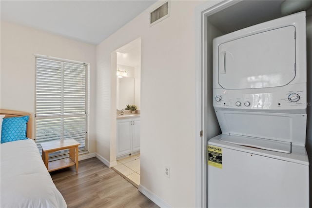 458 Cerromar Rd Unit 382, Venice, FL 34293 - laundry area featuring stacked washer / dryer, light wood-style flooring, and baseboards