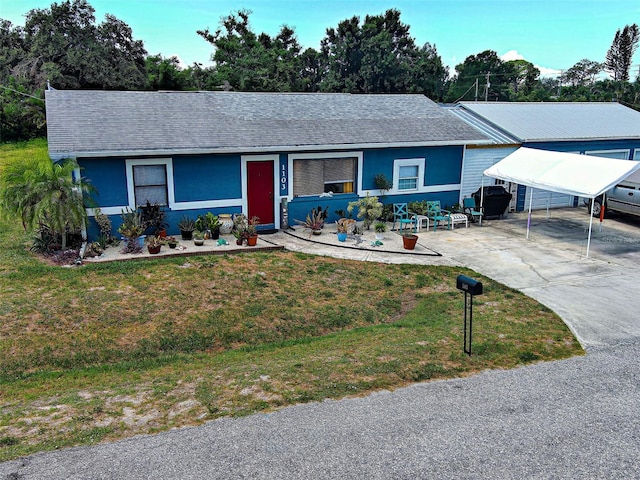 1103 Lucille Ave, Nokomis, FL 34275 - ranch-style house featuring a front yard, a carport, concrete driveway, and roof with shingles