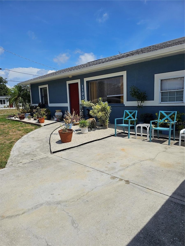 1103 Lucille Ave, Nokomis, FL 34275 - view of front facade with stucco siding and a patio area
