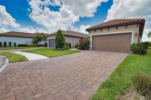 10410 Inglenook Ter, Palmetto, FL 34221 - mediterranean / spanish home featuring a front lawn, stucco siding, a tiled roof, and driveway