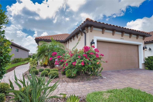 10410 Inglenook Ter, Palmetto, FL 34221 - view of front of property featuring a tiled roof, stucco siding, an attached garage, and decorative driveway