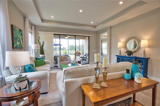 10410 Inglenook Ter, Palmetto, FL 34221 - living room featuring a tray ceiling, recessed lighting, wood finished floors, and baseboards