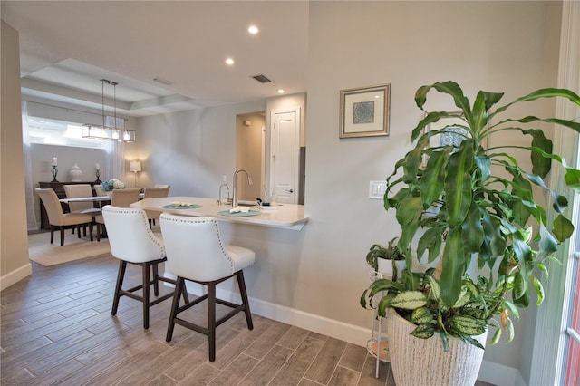 10410 Inglenook Ter, Palmetto, FL 34221 - kitchen featuring baseboards, a breakfast bar area, dark wood-style flooring, recessed lighting, and pendant lighting