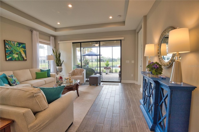 10410 Inglenook Ter, Palmetto, FL 34221 - living room featuring wood finished floors, healthy amount of natural light, a raised ceiling, recessed lighting, and baseboards