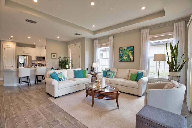 10410 Inglenook Ter, Palmetto, FL 34221 - living room featuring plenty of natural light, recessed lighting, a raised ceiling, and light wood-style flooring