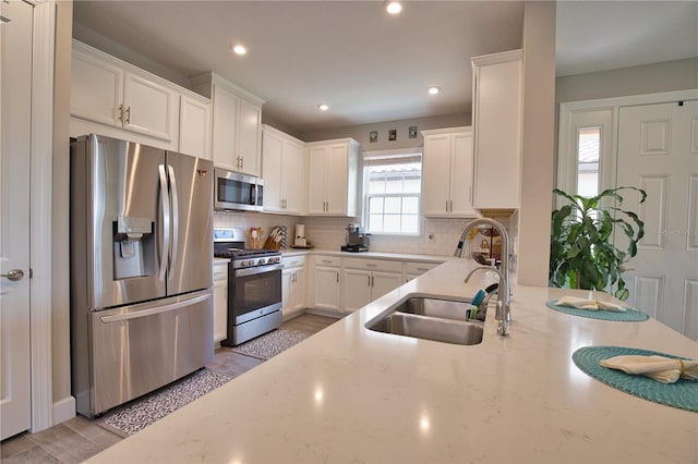 10410 Inglenook Ter, Palmetto, FL 34221 - kitchen featuring appliances with stainless steel finishes, a sink, decorative backsplash, recessed lighting, and white cabinetry