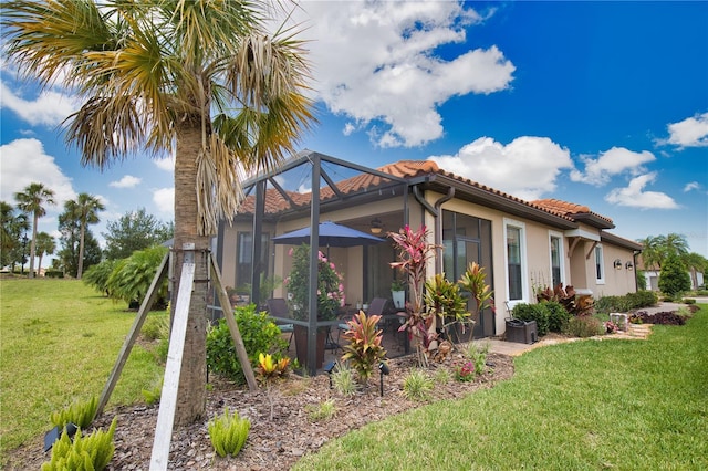 10410 Inglenook Ter, Palmetto, FL 34221 - rear view of house featuring a tiled roof, a yard, and stucco siding