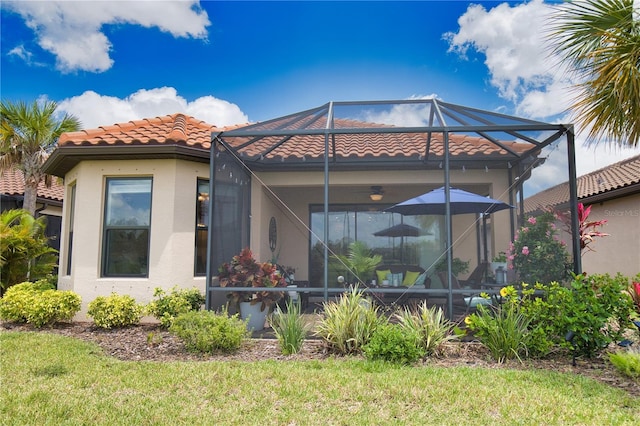 10410 Inglenook Ter, Palmetto, FL 34221 - back of house featuring glass enclosure, a tile roof, and stucco siding