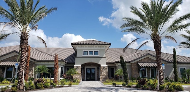 10410 Inglenook Ter, Palmetto, FL 34221 - mediterranean / spanish-style house with stucco siding, stone siding, a tile roof, and french doors