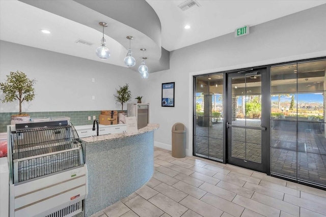 10410 Inglenook Ter, Palmetto, FL 34221 - kitchen with decorative backsplash, recessed lighting, light stone counters, plenty of natural light, and pendant lighting