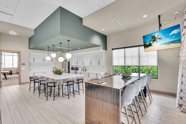 10410 Inglenook Ter, Palmetto, FL 34221 - kitchen featuring high end fridge, a spacious island, light wood finished floors, and a kitchen breakfast bar