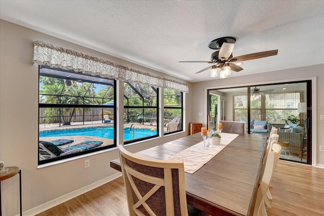 1515 Pecan St, Nokomis, FL 34275 - dining area with ceiling fan, a textured ceiling, light wood-style floors, and baseboards