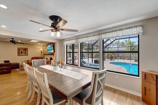 1515 Pecan St, Nokomis, FL 34275 - dining area featuring ceiling fan, light wood-style flooring, healthy amount of natural light, a textured ceiling, and baseboards