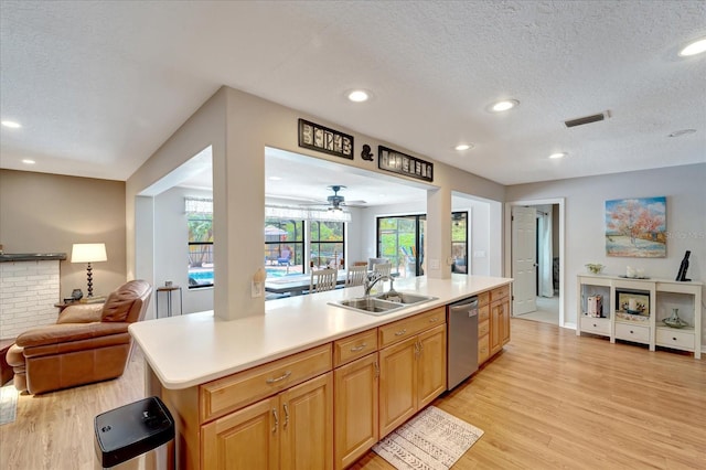 1515 Pecan St, Nokomis, FL 34275 - kitchen featuring open floor plan, stainless steel dishwasher, a sink, a textured ceiling, and light wood finished floors