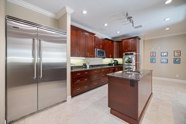 2322 Bayshore Rd, Nokomis, FL 34275 - kitchen with appliances with stainless steel finishes, ornamental molding, dark stone counters, baseboards, and recessed lighting