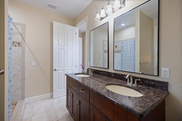2322 Bayshore Rd, Nokomis, FL 34275 - bathroom featuring double vanity, a tile shower, tile patterned floors, and baseboards