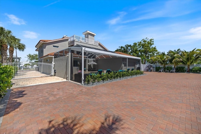 2322 Bayshore Rd, Nokomis, FL 34275 - back of house with a balcony, stucco siding, a patio area, and a gate