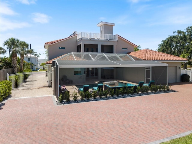 2322 Bayshore Rd, Nokomis, FL 34275 - rear view of house with stucco siding, a balcony, a gate, a garage, and a tile roof