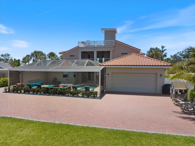 2322 Bayshore Rd, Nokomis, FL 34275 - view of front of property with stucco siding, an attached garage, a balcony, a tiled roof, and an outdoor pool