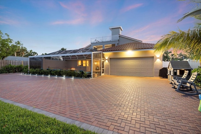 2322 Bayshore Rd, Nokomis, FL 34275 - view of front of property featuring stucco siding, a garage, a tile roof, a lanai, and decorative driveway