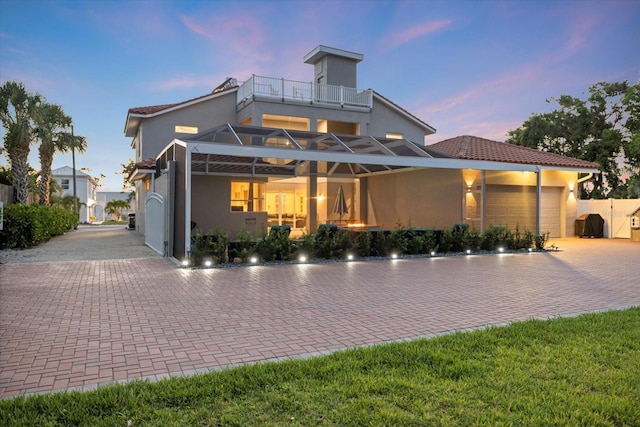 2322 Bayshore Rd, Nokomis, FL 34275 - contemporary home with a balcony, stucco siding, an attached garage, decorative driveway, and a lanai