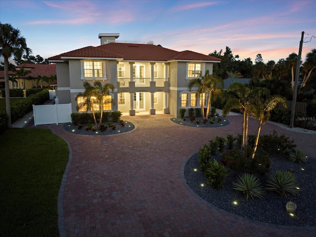 2322 Bayshore Rd, Nokomis, FL 34275 - view of front of house featuring a balcony, curved driveway, stucco siding, and a tile roof