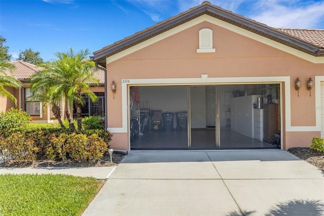 2104 Batello Dr, Venice, FL 34292 - exterior space featuring concrete driveway, stucco siding, and an attached garage