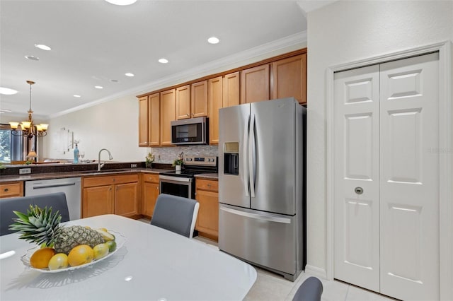 2104 Batello Dr, Venice, FL 34292 - kitchen with appliances with stainless steel finishes, a sink, ornamental molding, a chandelier, and dark countertops