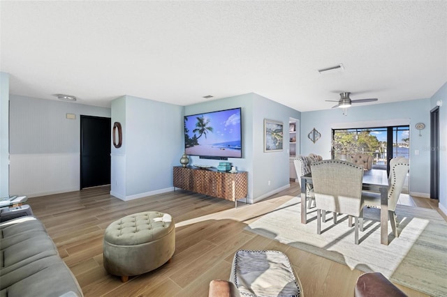 5140 Administration St, Port Charlotte, FL 33948 - living area with light wood-style flooring, a wainscoted wall, ceiling fan, and baseboards