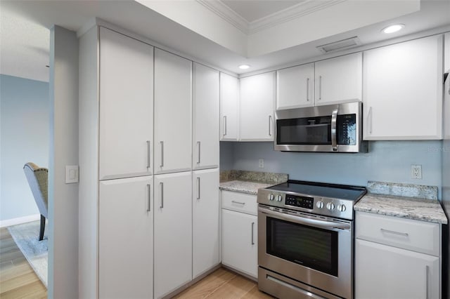 5140 Administration St, Port Charlotte, FL 33948 - kitchen featuring appliances with stainless steel finishes, crown molding, light wood-style flooring, white cabinets, and recessed lighting