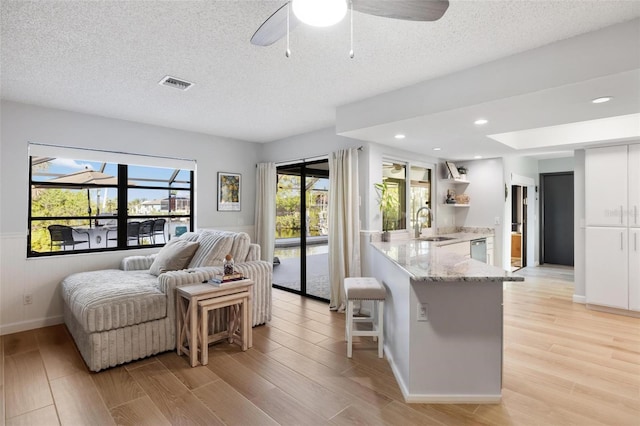 5140 Administration St, Port Charlotte, FL 33948 - living room featuring light wood-style floors, a textured ceiling, baseboards, a ceiling fan, and recessed lighting