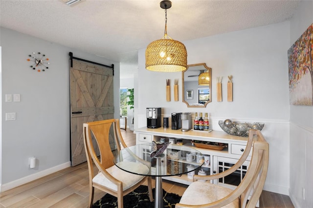 5140 Administration St, Port Charlotte, FL 33948 - dining area with wood finished floors, a textured ceiling, and a barn door
