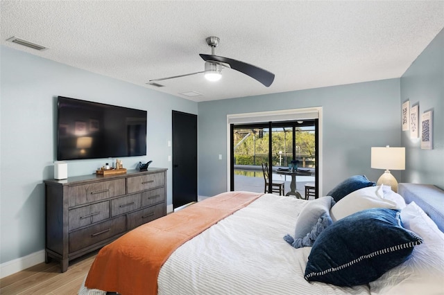 5140 Administration St, Port Charlotte, FL 33948 - bedroom featuring access to exterior, light wood finished floors, a textured ceiling, baseboards, and a ceiling fan