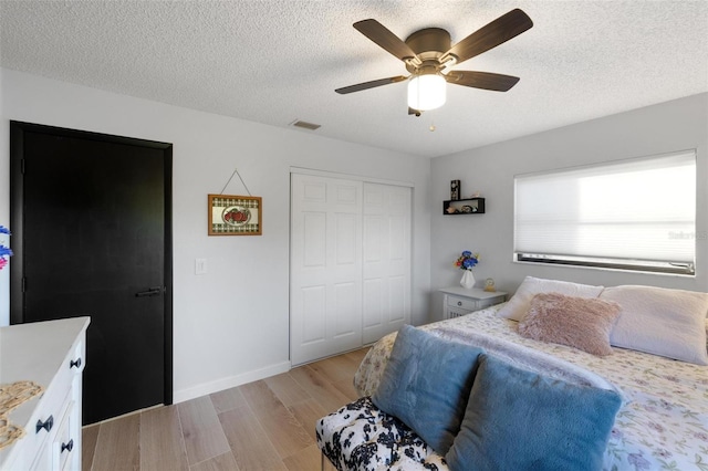 5140 Administration St, Port Charlotte, FL 33948 - bedroom with a closet, light wood finished floors, a textured ceiling, a ceiling fan, and baseboards
