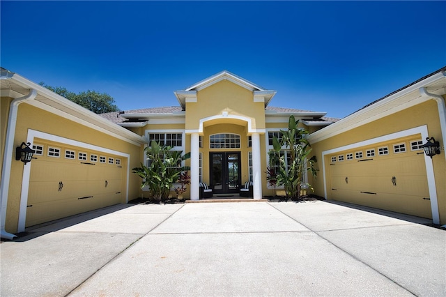 8209 Snowy Egret Pl, Bradenton, FL 34202 - doorway to property with french doors, driveway, stucco siding, and an attached garage