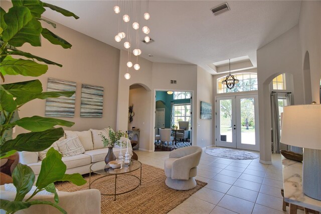 8209 Snowy Egret Pl, Bradenton, FL 34202 - living area with arched walkways, a high ceiling, tile patterned flooring, french doors, and baseboards