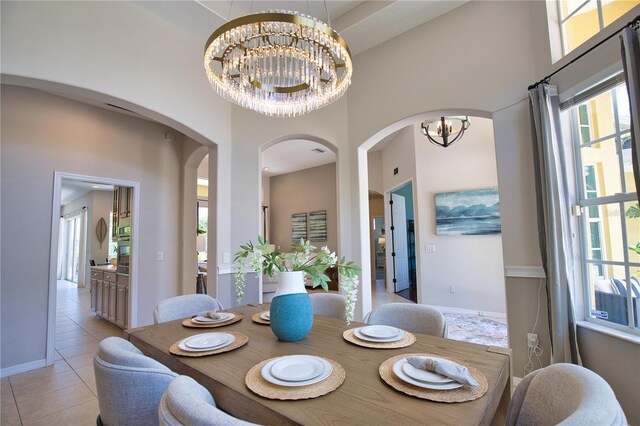 8209 Snowy Egret Pl, Bradenton, FL 34202 - dining area with a chandelier, a towering ceiling, arched walkways, light tile patterned floors, and plenty of natural light