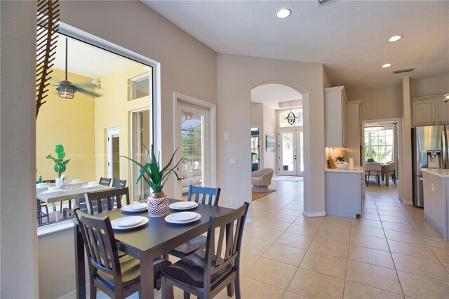 8209 Snowy Egret Pl, Bradenton, FL 34202 - dining space featuring arched walkways, light tile patterned floors, recessed lighting, and a textured ceiling