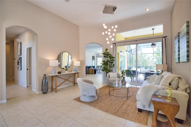 8209 Snowy Egret Pl, Bradenton, FL 34202 - living room featuring arched walkways, light tile patterned floors, plenty of natural light, a towering ceiling, and a sunroom