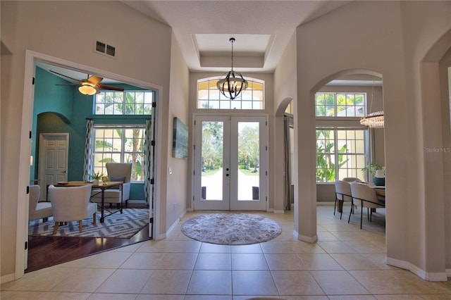 8209 Snowy Egret Pl, Bradenton, FL 34202 - foyer entrance with arched walkways, baseboards, a high ceiling, a raised ceiling, and french doors