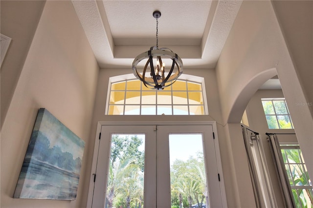 8209 Snowy Egret Pl, Bradenton, FL 34202 - entrance foyer featuring a chandelier, arched walkways, a tray ceiling, and a high ceiling