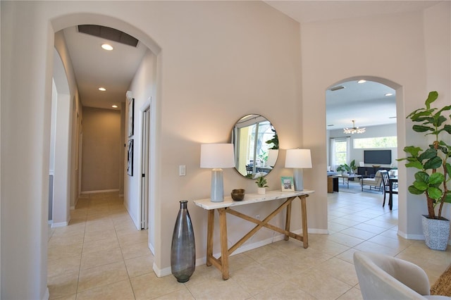 8209 Snowy Egret Pl, Bradenton, FL 34202 - hall featuring arched walkways, light tile patterned flooring, recessed lighting, and a chandelier