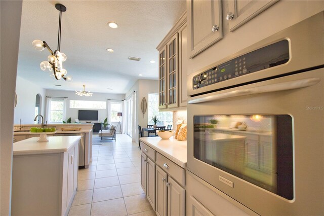 8209 Snowy Egret Pl, Bradenton, FL 34202 - kitchen featuring stainless steel oven, light countertops, light tile patterned floors, a chandelier, and open floor plan