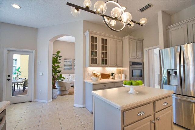 8209 Snowy Egret Pl, Bradenton, FL 34202 - kitchen featuring stainless steel appliances, arched walkways, light countertops, backsplash, and a chandelier