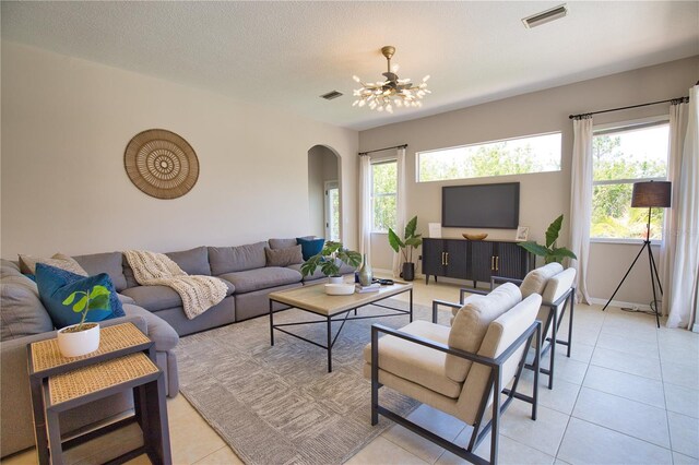8209 Snowy Egret Pl, Bradenton, FL 34202 - living area with arched walkways, healthy amount of natural light, and light tile patterned floors