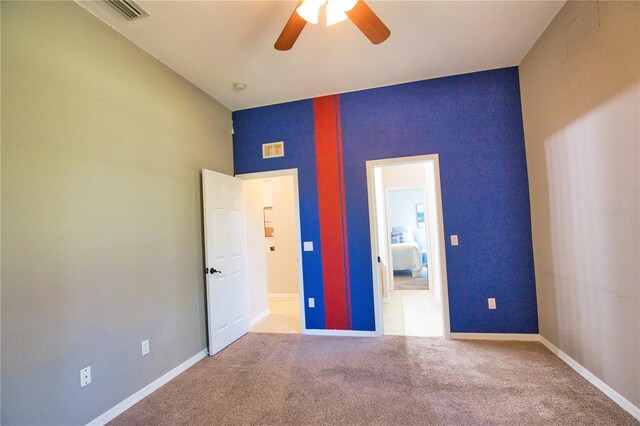 8209 Snowy Egret Pl, Bradenton, FL 34202 - unfurnished bedroom with baseboards, carpet floors, an accent wall, and a ceiling fan