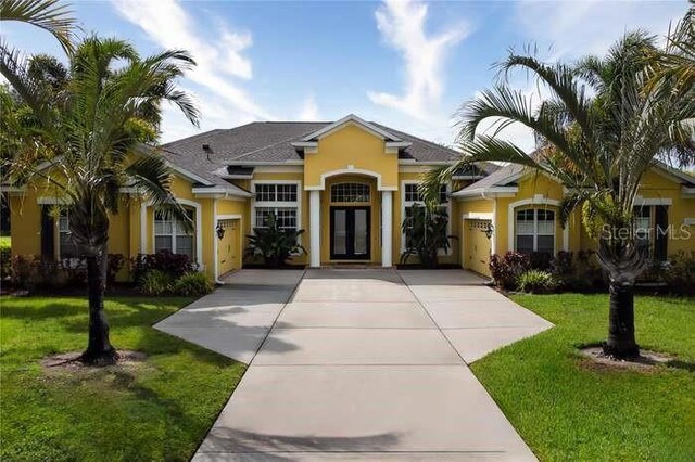 8209 Snowy Egret Pl, Bradenton, FL 34202 - view of front of property with stucco siding, french doors, and a front lawn