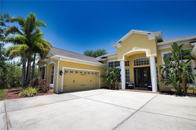8209 Snowy Egret Pl, Bradenton, FL 34202 - view of front facade with french doors, concrete driveway, stucco siding, and an attached garage