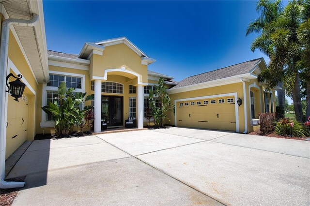 8209 Snowy Egret Pl, Bradenton, FL 34202 - view of front facade with stucco siding, an attached garage, driveway, and a shingled roof