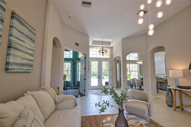 8209 Snowy Egret Pl, Bradenton, FL 34202 - living room featuring arched walkways, a high ceiling, light tile patterned floors, and french doors
